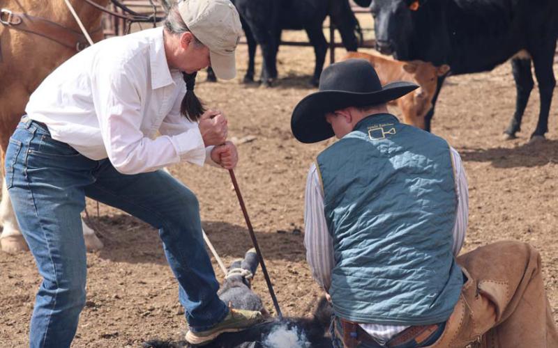 Kyle Peebles is a woman with plenty of grit. Here, she brands a calf while her husband holds the rope tight on horseback and her son keeps the calf still. joycesarah mccabe | dispatch record