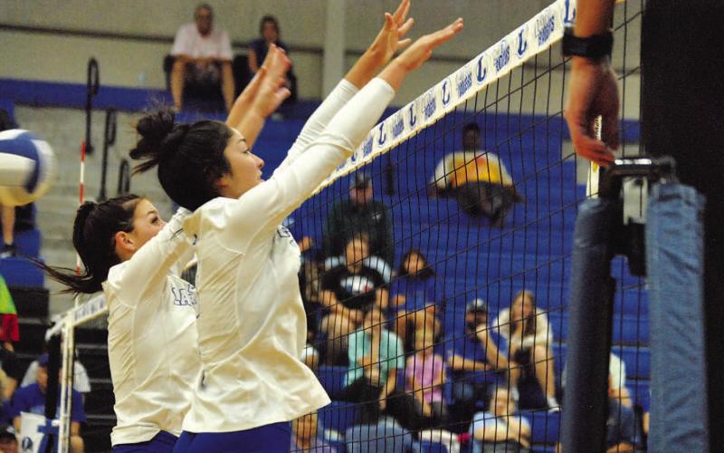 Landry White, left, and Lilee Hamill jump for a block during Tuesday’s contest at home. HUNTER KING | DISPATCH RECORD