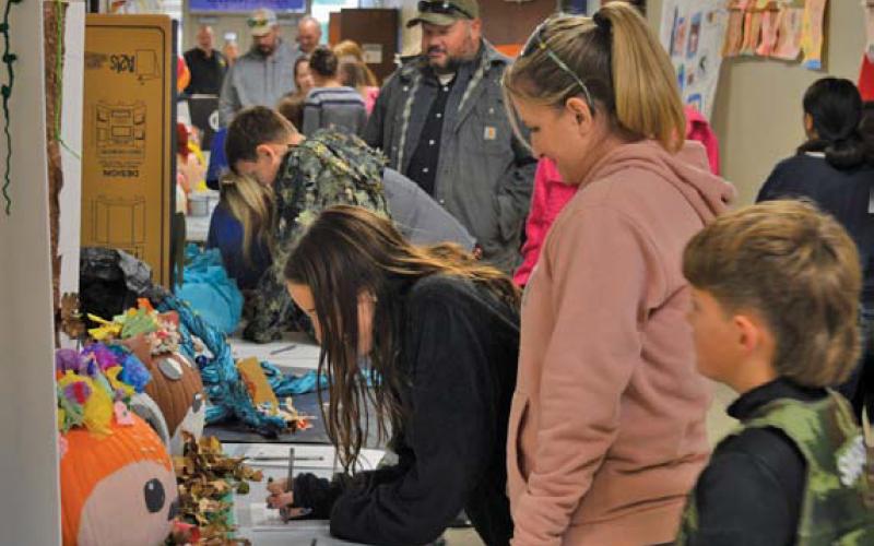 Student-decorated pumpkins line the hallway during Monday night’s Fall Fest at Kline Whitis Elementary. The PTA sponsored a contest, with Police Chief Jody Cummings and Fire Chief Jeff Smith serving as judges. Pumpkins were auctioned afterward. erick mitchell | dispatch record