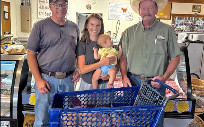 Farm Bureau Director Rusty Calk, at left, is pictured with new member and Family Meat Pack winner Jenna Argo and her baby, Nora. They are joined by M&amp;amp;M Butcher Block owner Stephen Meyer as Argo collected her prize winnings. Courtesy photo