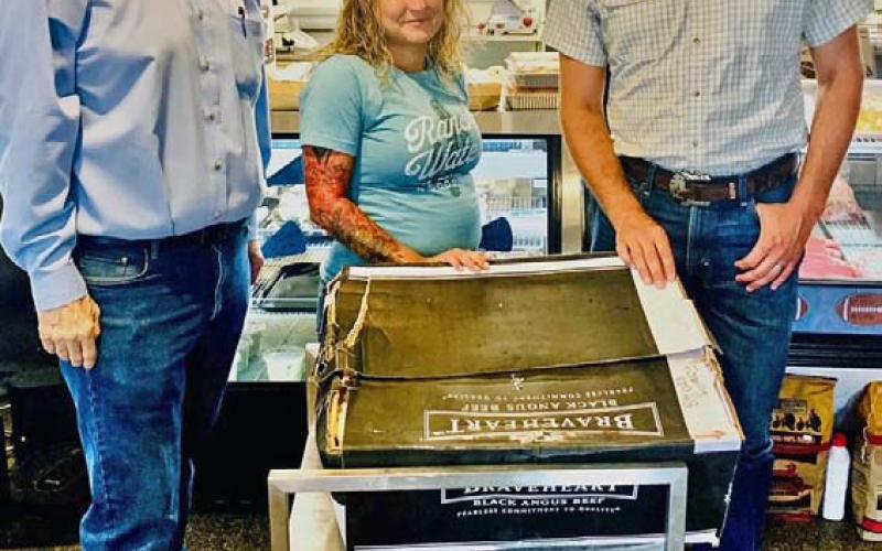 Farm Bureau Director Dr. Steve Forsythe, at left, and Lampasas County Farm Bureau President Heston McBride congratulate new member Charlotte Hawkins on being selected to take home a Family Meat Pack from M&amp;amp;M Butcher Block. courtesy photo
