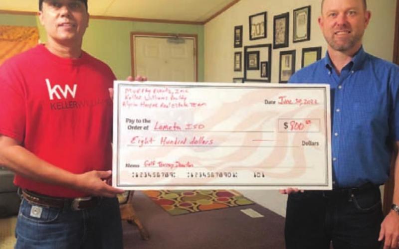 Kenneth Murray, left, hands a check to Lometa ISD Superintendent Rob Moore. COURTESY PHOTO