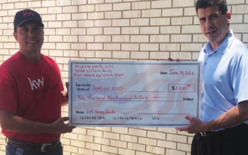 Lampasas Superintendent Chane Rascoe, left, receives a check from Murray. COURTESY PHOTO