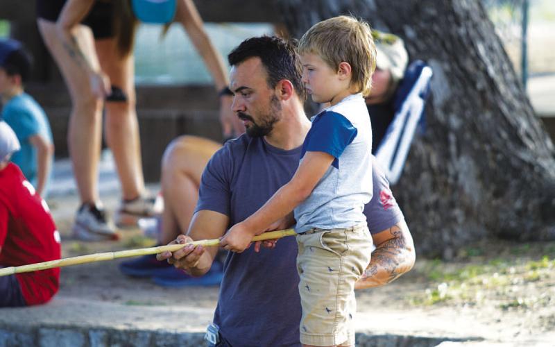 HUNTER KING | DISPATCH RECORD Travis Akers and his son Easton Akers wait for a fish to bite during Wednesday’s event.