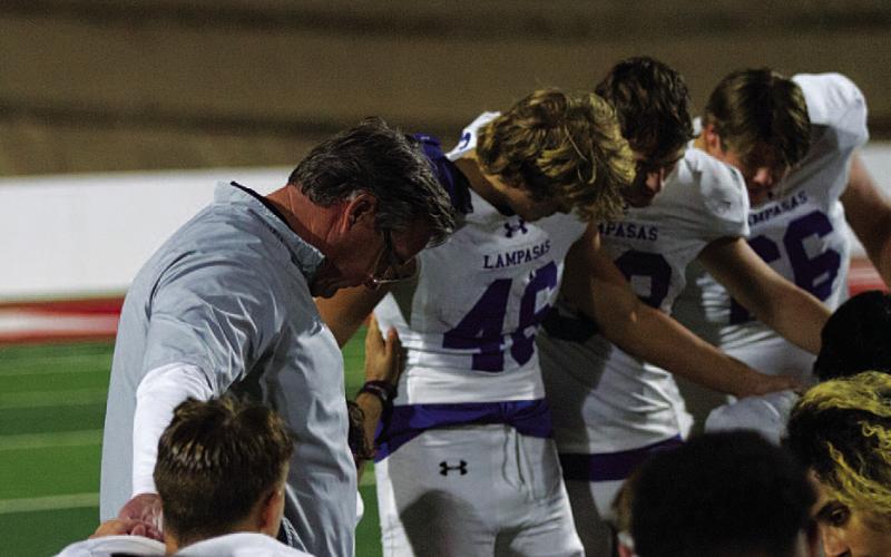 HUNTER KING | DISPATCH RECORD Head coach Troy Rogers bows his head to pray with his team after last Friday’s playoff game.