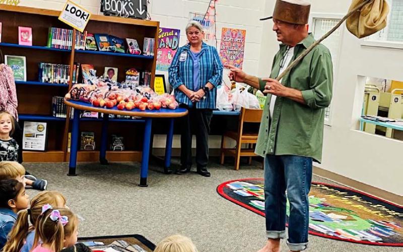 Johnny Appleseed visits with pre-K and kindergarten students at Taylor Creek Elementary, where he shared information about his life and activities. Appleseed also brought treats of apples and applesauce for students. COURTESY PHOTO
