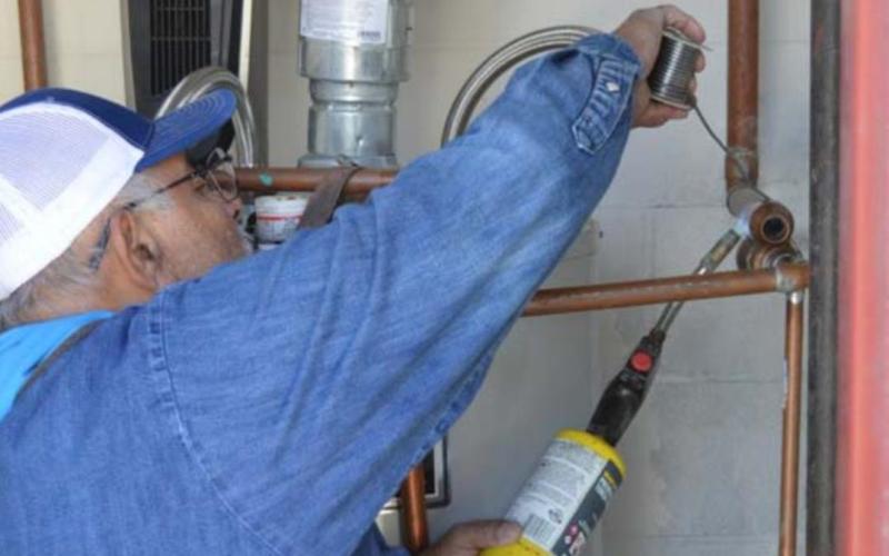 Lampasas ISD Maintenance Department employee Jesse Ramirez solders a copper line at the former Lampasas Middle School campus after record cold caused a leak. JEFF LOWE | DISPATCH RECORD