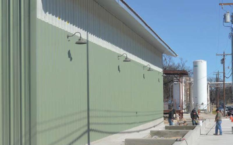 Plant beds and a new sidewalk are visible behind the newly erected metal building on East Second Street. erick mitchell | dispatch record