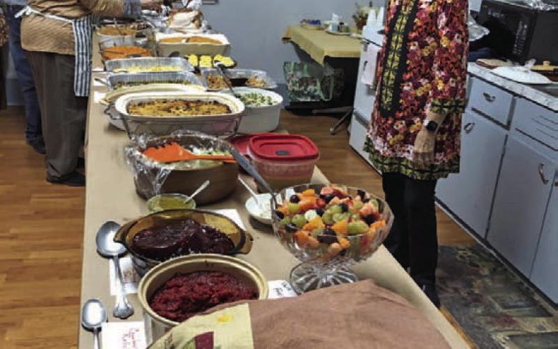 The Thanksgiving spread included many scrumptious dishes prepared by L-M Garden and Civic Club members. Tico Hicks, shown here, helped with preparations and provided a butter turkey. COURTESY PHOTO