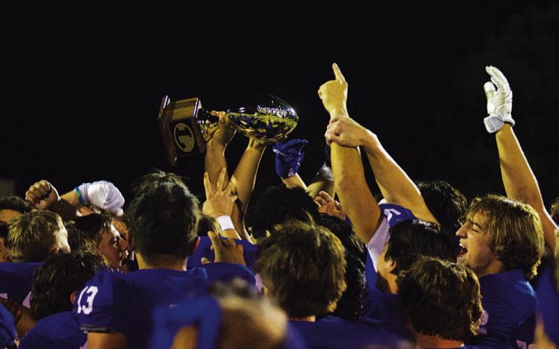 The Badger football team raises their new golden football after winning over Pecos last Thursday night. HUNTER KING | DISPATCH RECORD