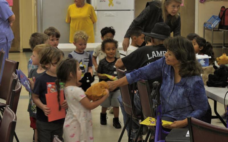 Lampasas senior residents were over the moon to hand youngsters reversible bear/bull puppets that represent stock market activity. ERICK MITCHELL |DISPATCH RECORD