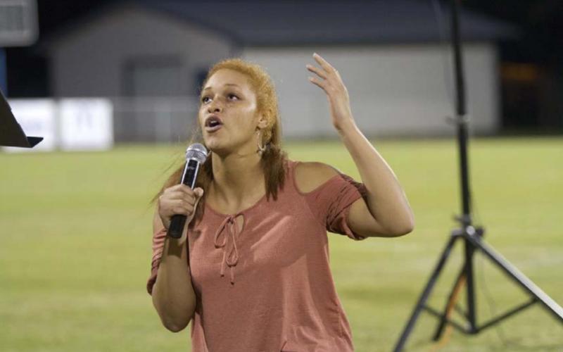 Juliana Dwamena takes a knee and speaks to God during Fields of Faith. HUNTER KING | DISPATCH RECORD