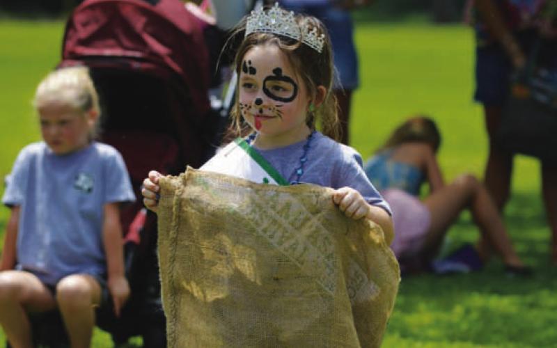 Little Miss Spring Ho Berkley Ann Shuffler eyes the finish line before competing in a sack-hopping relay race. ERICK MITCHELL | DISPATCH RECORD