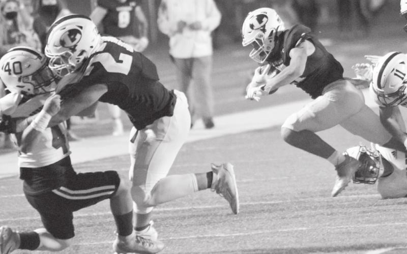 Aden Rascoe (27) blocks a Uvalde Coyote as Ethan Moreno, right, breaks tackles in the Badgers’ 61-14 bi-district playoff win last week. JEFF LOWE | DISPATCH RECORD