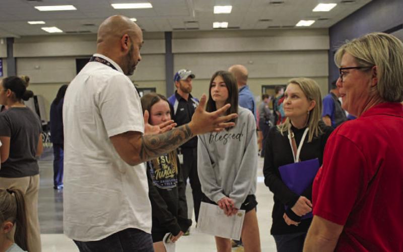Lola Patterson and her mother, Maurine Patterson, learn about the culinary arts program from teacher Jason Walsh during Ninth-grade Preview Night last week at the high school. VERONICA BUTLER | DISPATCH RECORD