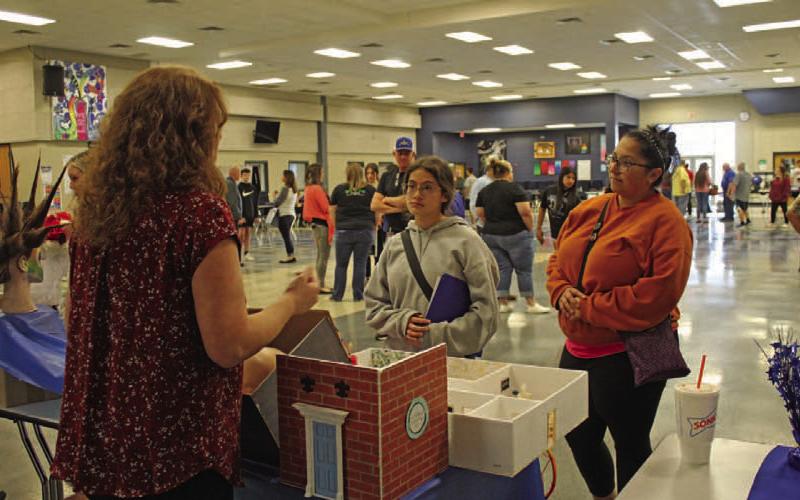 Frances Mitchell and her eighth-grader Trinity Doyle discuss cosmetology courses offered at Lampasas High School with teacher Christine Hearn at the ninth-grade preview event. VERONICA BUTLER | DISPATCH RECORD