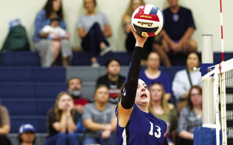 Abbey Green tips the ball over the net during Tuesday’s match on the road. HUNTER KING | DISPATCH RECORD