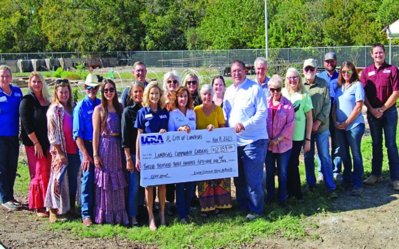 Lampasas Community Garden Director Janet Crozier stands in center, between Mayor Herb Pearce and LCRA representatives Carol Freeman and Meg Voelter to receive a grant for projects and improvement for the garden.