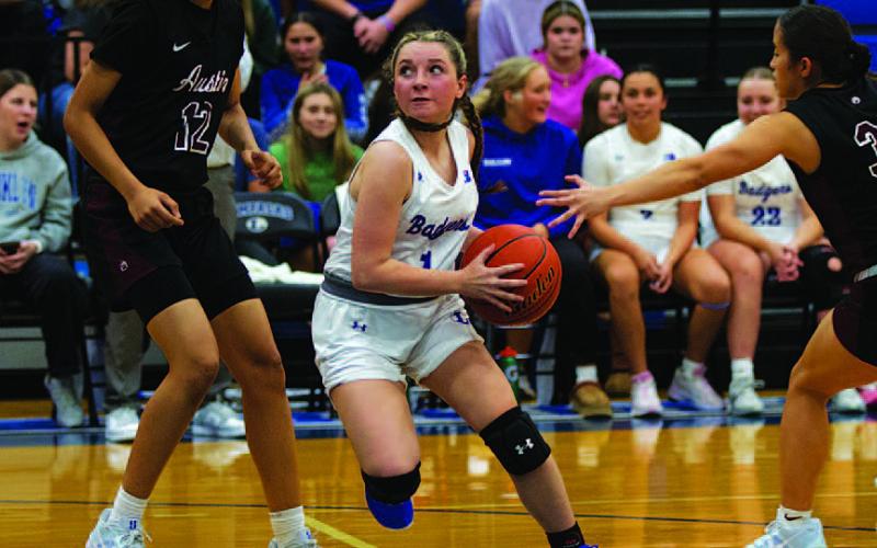 Abra White drives past Austin High defenders for two points during Tuesday night’s game. HUNTER KING | DISPATCH RECORD