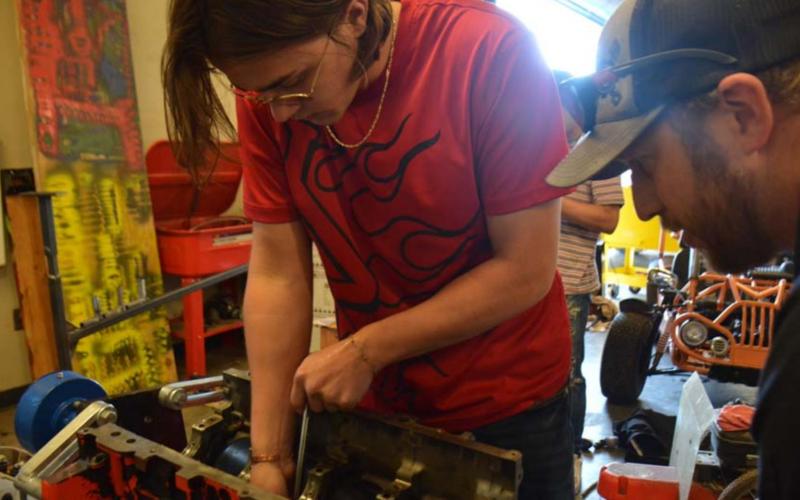 Lampasas High School senior Cohen White, left, and auto tech teacher Edward Gold work to install cam bearings in an LS motor Tuesday afternoon. MONIQUE BRAND | DISPATCH RECORD
