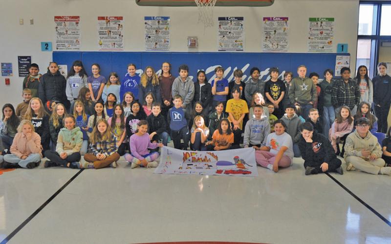 Erick mitchell | dispatch record Fifth-grade students at Kline Whitis Elementary School pose for a photo Tuesday with the flag that represents their campus. The flag was designed for National Fire Prevention Week back in October.