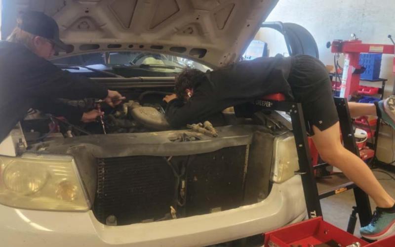 Lampasas High School Auto Tech II students Chris Vincent, left, and Nathan Abken are shown working on a pickup. The Hoffpauir dealership has partnered with the school district to offer students training in various aspects of the automotive repair industry. COURTESY PHOTO