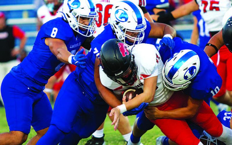 Elijah Calderon (8), Cameron Russell-Hill (70) and Carter Kuhn (10) are in on the tackle of the Lorena quarterback. HUNTER KING | DISPATCH RECORD