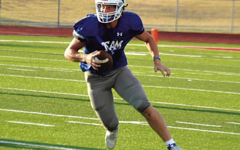 HUNTER KING | DISPATCH RECORD Reed Jerome scrambles to his left before running up field during the Badgers’ scoring drive.