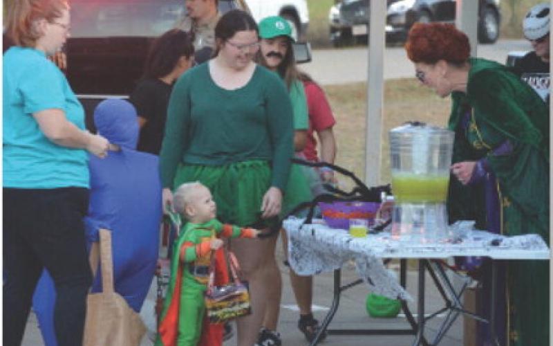 At right, Kempner City Manager Rebecca Ramos helps a trunk-or-treater to a cup of punch during last year’s event. This year’s event will take place at the Sylvia Tucker Memorial Park. courtesy photo | Johnny Anderson