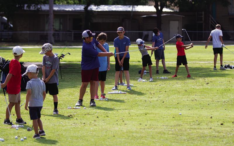 Young golfers work on their short shots during golf camp last Tuesday. HUNTER KING | DISPATCH RECORD