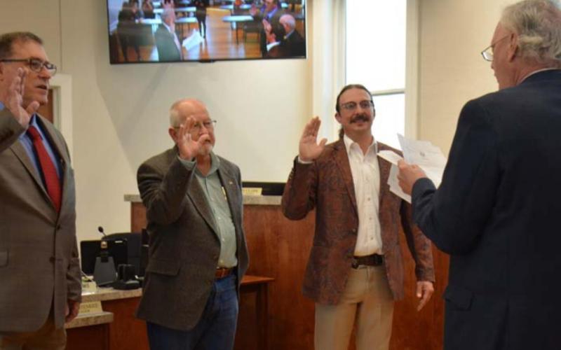 New Lampasas City Councilmen members Herb Pearce, left, and Zac Morris, second from right -- along with returning councilman Randy Clark -- take the oath of office Monday. Municipal Court Judge Robert Gradel administered the oath of office. MONIQUE BRAND | DISPATCH RECORD