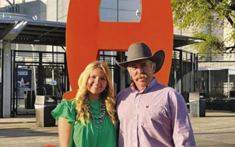 Kari Greiner is shown with her father, Corey, at a major show. Greiner competed in San Antonio, Houston and Fort Worth in each of the three years she showed animals. COURTESY PHOTO