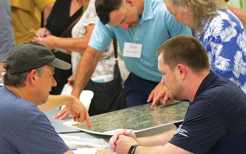 Area property owners pour over maps of the proposed electric transmission line routes at Tuesday’s open house hosted by Oncor and LCRA representatives. hunter king | dispatch record