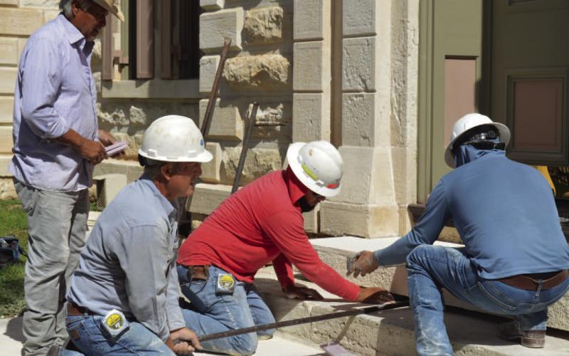 Flint Hughes and his masonry crew work to replace a threshold stone at the Lampasas County Courthouse. Renovation on the historic structure extended through most of 2025. FILE PHOTO