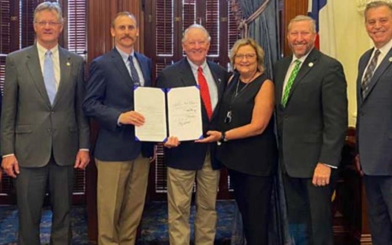 Present for the governor’s June 4 signing of an updated farm animal liability bill are, from left, Rep. DeWayne Burns, Rep. Glenn Rogers, Rep. Andrew Murr, Mickey and Jani Edwards of Lampasas, Sen. Drew Springer, Rep. David Spiller and Rep. Doc Anderson. COURTESY PHOTO