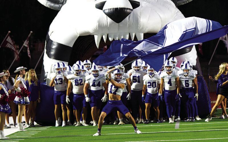 Sean Smith waves the flag ahead of the Badgers’ game against Brownwood last Friday.