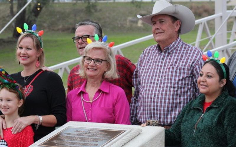 Friends and loved ones of the late Katherine Mezger gather at the newly erected bronze and stone memorial in W.M. Brook Park to celebrate her dedication to the Christmas on the Creek event. The event has grown every year in terms of displays offered and Lampasans who celebrate the Christmas season at the park with its festive lighting. Mezger was a driving force behind bringing the celebration to the community for all to enjoy. joycesarah mccabe | dispatch record