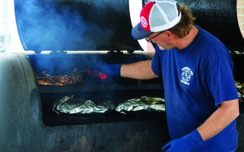 Kempner Volunteer Fire Department Capt. Todd Burkett smokes brisket to the perfect temperature during last year’s event. This year’s BBQ and Auction Fundraiser is set for April 18. FILE PHOTO