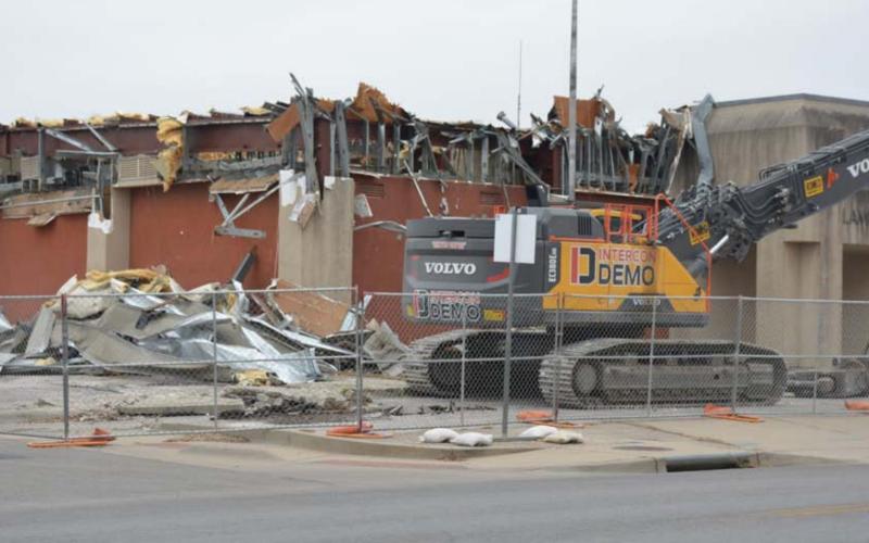 The exterior of the old county jail was broken down by Alamo 1 construction cranes on Wednesday afternoon. Additional abestos was discovered in the building roof during last week’s abatement, according to an Alamo 1 employee. MONIQUE BRAND | DISPATCH RECORD