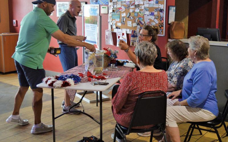 erick mitchell | dispatch record Putters &amp;amp; Gutters guests make donations to the American Legion Auxiliary in honor of National Poppy Day, which was recognized last Friday. Auxiliary volunteers were at the local business to hand out red poppies in memory of America’s fallen heroes.