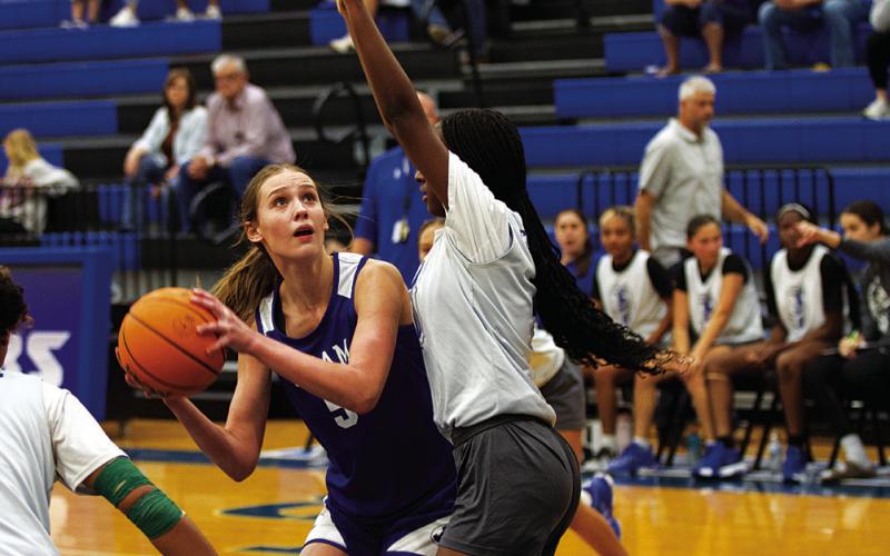 HUNTER KING | DISPATCH RECORD Lainey Dixon looks to shoot over a defender for Manor New Tech during the Lady Badgers’ first scrimmage on Tuesday.