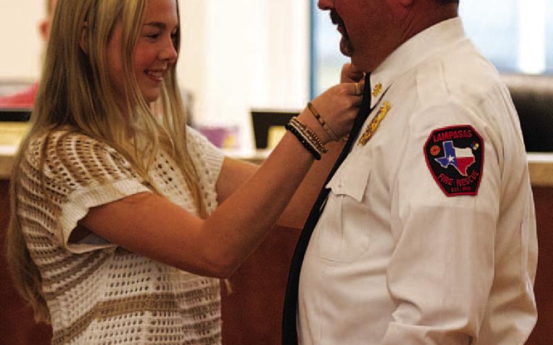 Troy Davis receives his fire chief pin from daughter Shelby Davis at a brief ceremony Monday during the Lampasas City Council meeting. Davis officially was recognized as the new chief for the Lampasas Fire Department, after serving several months as the interim chief. HUNTER KING | DISPATCH RECORD