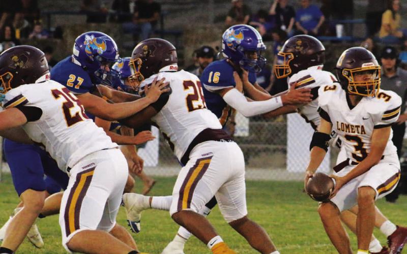 Jordan Livesay pitches the ball behind Lometa’s offensive line of, left to right, Roy Carr, Emmanuel Prado and Colten Whitehead. MASON HINES | DISPATCH RECORD