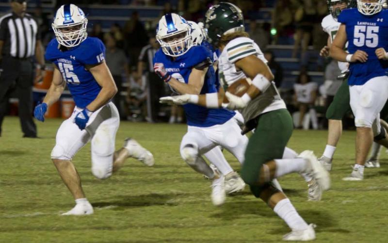 Case Brister, left, and Carson Bekker pursue a Canyon Lake ball carrier during last week’s game. HUNTER KING | DISPATCH RECORD