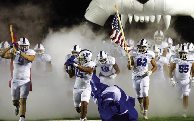 HUNTER KING | DISPATCH RECORD Brady Renfrew (9), Dailan Fagan (15) and Nick Torrez (62) lead the Badgers onto the field.