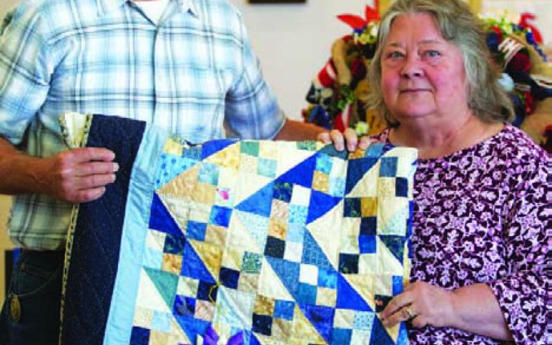 Connie Hamill was named the overall grand champion of the County Fair with this quilt. County Judge Randy Howyer is photographed with her. HUNTER KING | DISPATCH RECORD