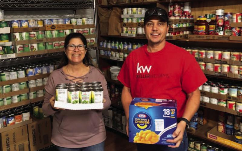 Kenny Murray of Keller Williams Real Estate joined forces with the Alycia Hooper Real Estate team on their second annual community food drive. The group collected and donated 1,473 pounds of food to St. Mary’s Catholic Church Food Pantry. Pictured are pantry volunteer Beth James and Kenny Murray, left to right. COURTESY PHOTO