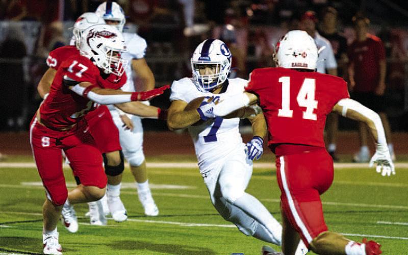 HUNTER KING | DISPATCH RECORD Daemian Rivas splits two Salado defenders. The senior ran for 144 yards last Friday night.