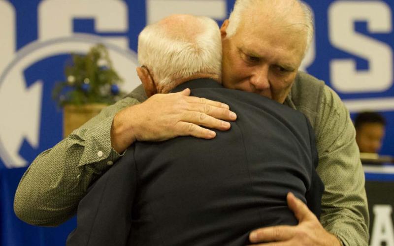 Curtis Thrift, a former Lampasas Badger standout hugs his former coach Ken Wiginton after speaking on him during his Hall of Fame induction at the 2021 Badger Football Banquet last Monday. HUNTER KING | DISPATCH RECORD