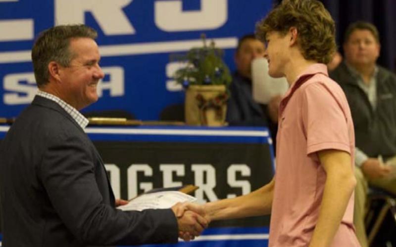 Nate Borchardt shakes hands with Rogers as he receives the Most Eligible Receiver Award. HUNTER KING | DISPATCH RECORD